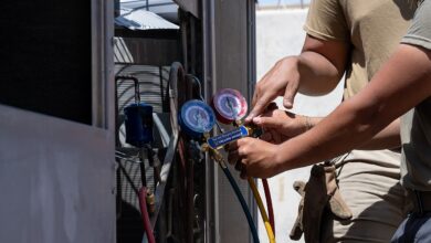 فنّي يقيس ضغط الفريون بمانيفولد على الوحدة الخارجية للمكيف